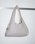 Gray handbag with white interior lining on a light gray background