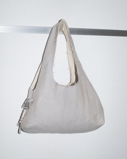 Gray handbag with white interior lining on a light gray background